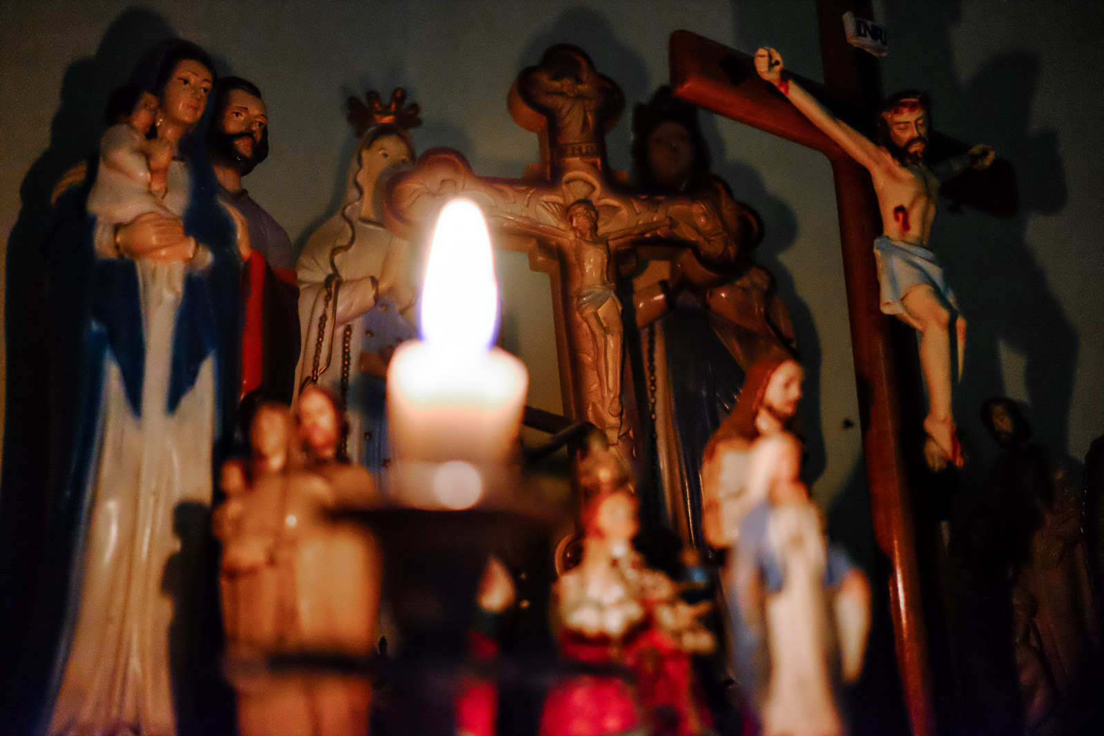 Figurines depicting Catholic icons seen on the surface of a dresser on June 5, 2019 at the home of Mama Emy in Kupang, Indonesia. Neighbors come to Mama Emy throughout the day to receive spiritual consultations and be prayed over.
