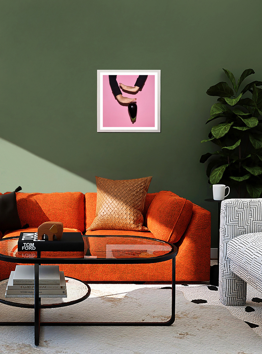 A pink and black colored artwork by N. A. Vague hanging on a green wall in a stylish furnished living room