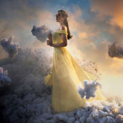 Photographic Art of A person in a yellow dress, floating in clouds with a sky background.