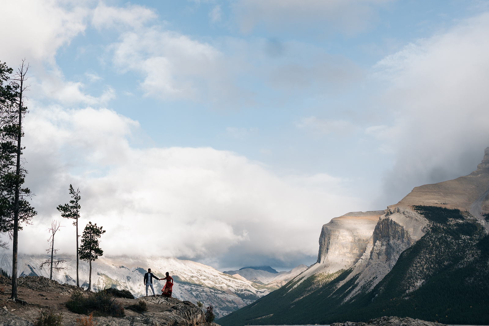 A bride and groom's silhouette with mountains behind them.