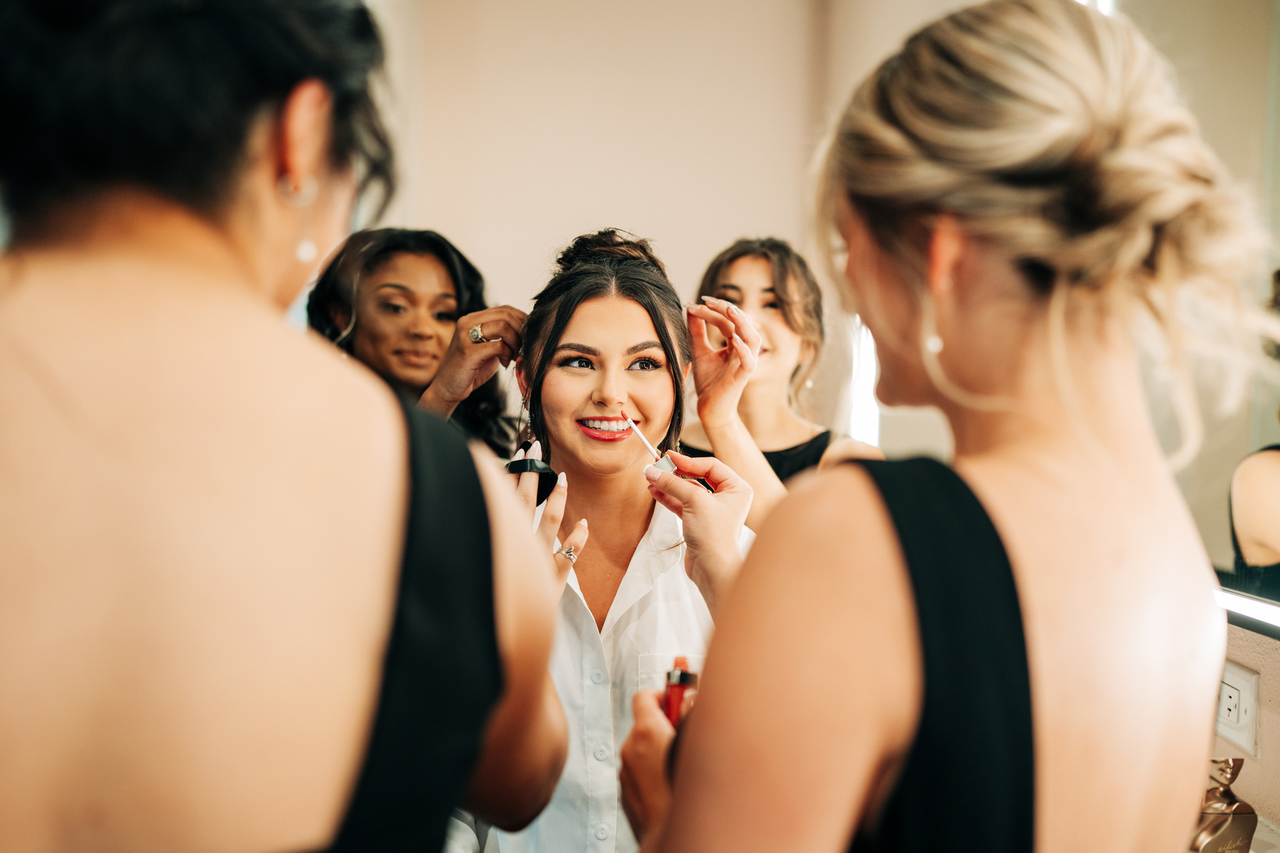 Bridesmaids helping their bride get ready before her ceremony in Houston, TX.