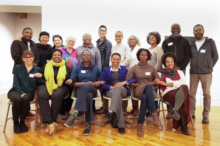 A group of 17 people, closely gathered, posed for the photo.