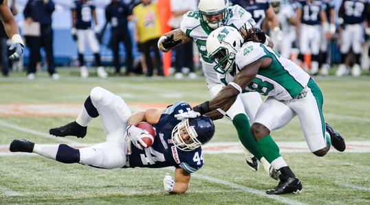 TORONTO, Ont. (11/07/2013) - Saskatchewan Roughriders linebacker, Renauld Williams (48) tackles Toronto Argonauts, running back Chad Kackert (44) in Toronto, Ont. at the Rogers Centre Thursday night.  The Argonauts were not able to defend their home turf 