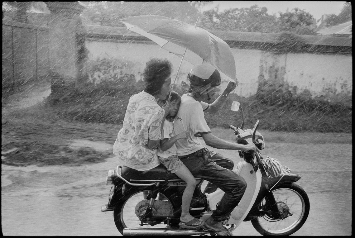 Nicholas Blair photography copyright 1981, black and white, Family on Motorcycle in Rain