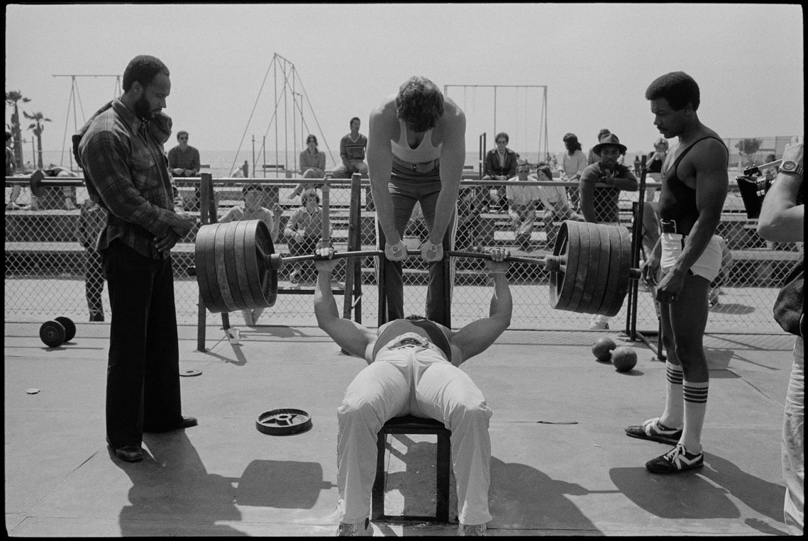 Nicholas Blair photography copyright 1985, black and white, Man bench pressing 600 pounds, inter-racial, weight lifting