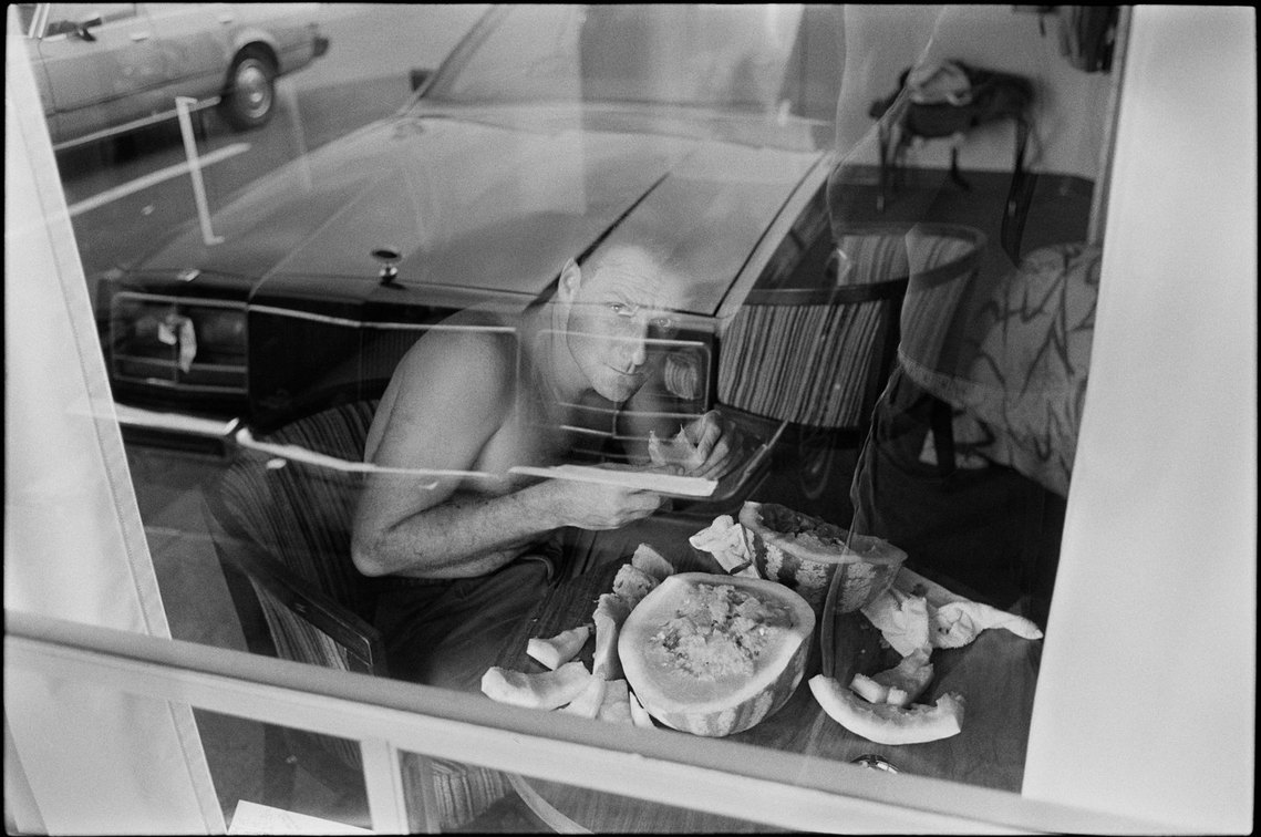 Nicholas Blair photography copyright 1985, black and white, reflection, man eating watermelon