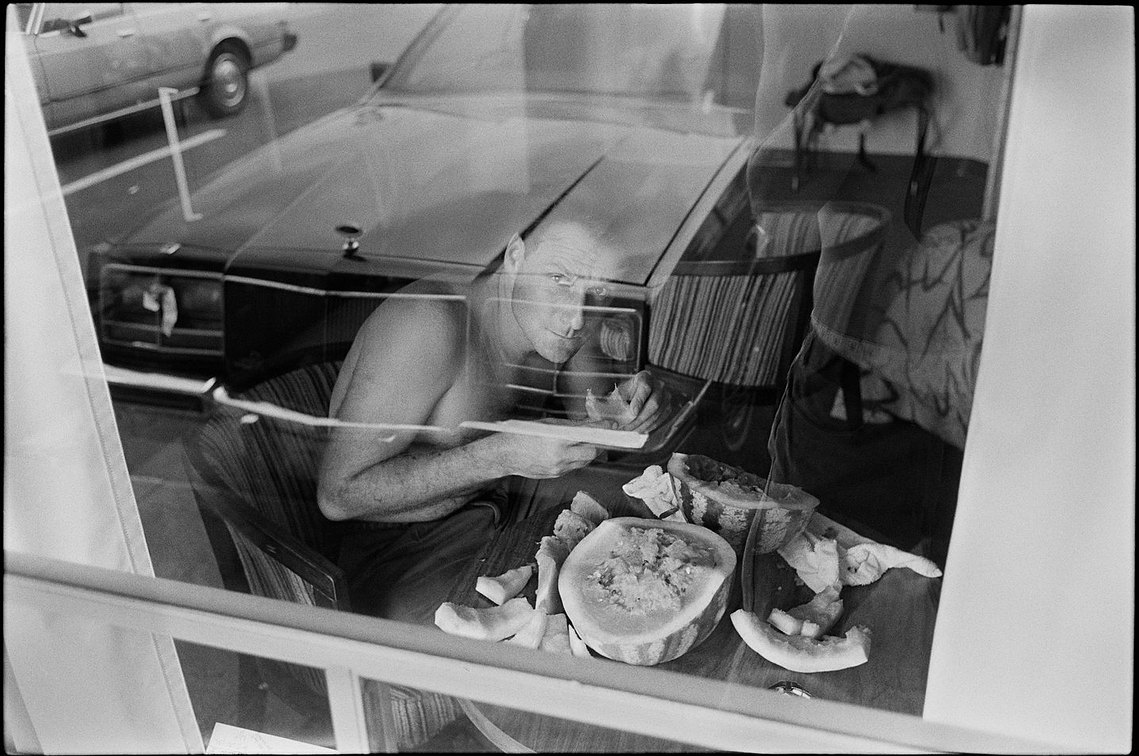 Nicholas Blair photography copyright 1985, black and white, reflection, man eating watermelon