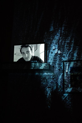 Digital portrait on a laptop screen with an image of a tree bark dripping a white liquid into the background.