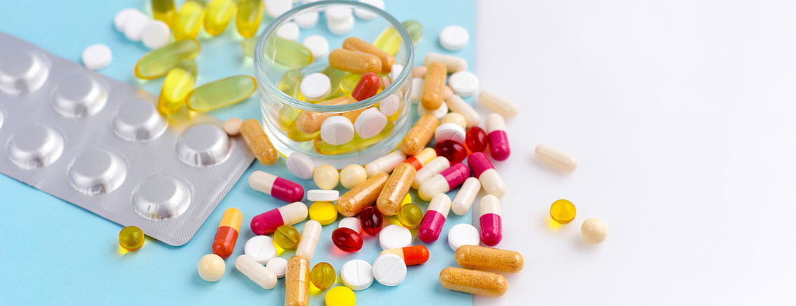 Vibrant blue background with multiple kinds of medications scattered around.
