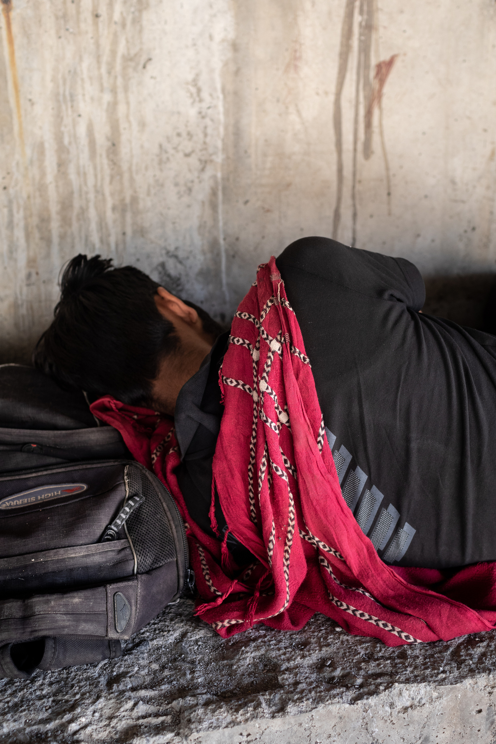 A young man from Afghanistan sleeps using his backpack as a pillow, under a bridge, next to some railway lines on the outskirts of the eastern Turkish city of Tatvan. As Afghanistan comes under Taliban rule, tens of thousands have fled westward through Ir
