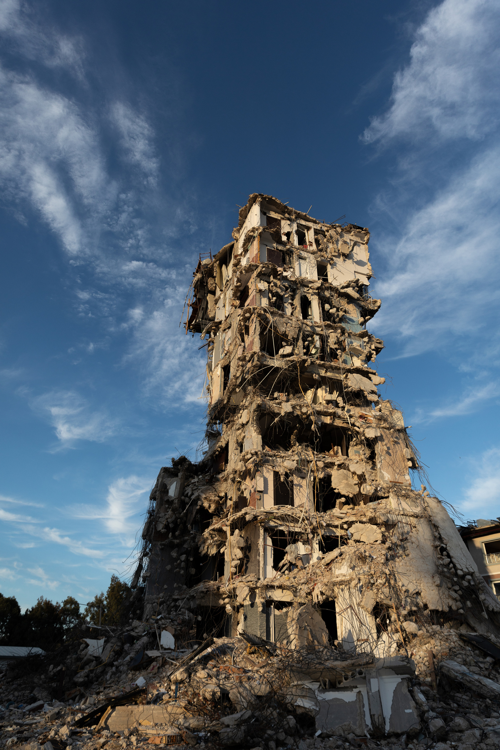 The skeleton of a damaged building looms into the sky, above the ruins and rubble of collapsed ones surrounding it. Antakya was hit by two severe earthquakes on the 6th of February this year, followed by several others, and hundreds of aftershocks.