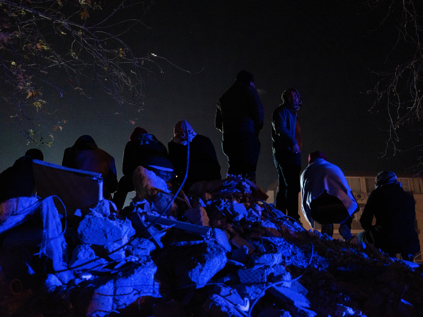 Watching on with hope - former residents of apartment blocks destroyed by the earthquake, wait next to rescue workers, for news on their loved ones.