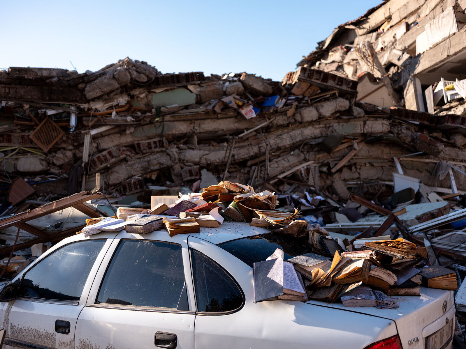 Religious books, saved from the destroyed ruins of the tens of collapsed buildings in central Kahramanmaras, southern Turkey, placed on top of a car, as a sign of respect to the texts.
The destroyed southern Turkish town of Kahramanmaras, close to the e