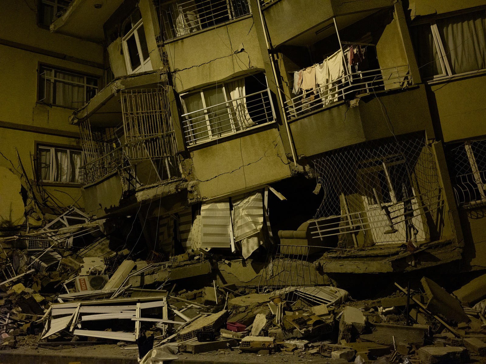 A building not yet reached by search and rescue workers, said to have a survivor trapped inside, according to former neighbours, who stand nearby, waiting to direct help to the building.