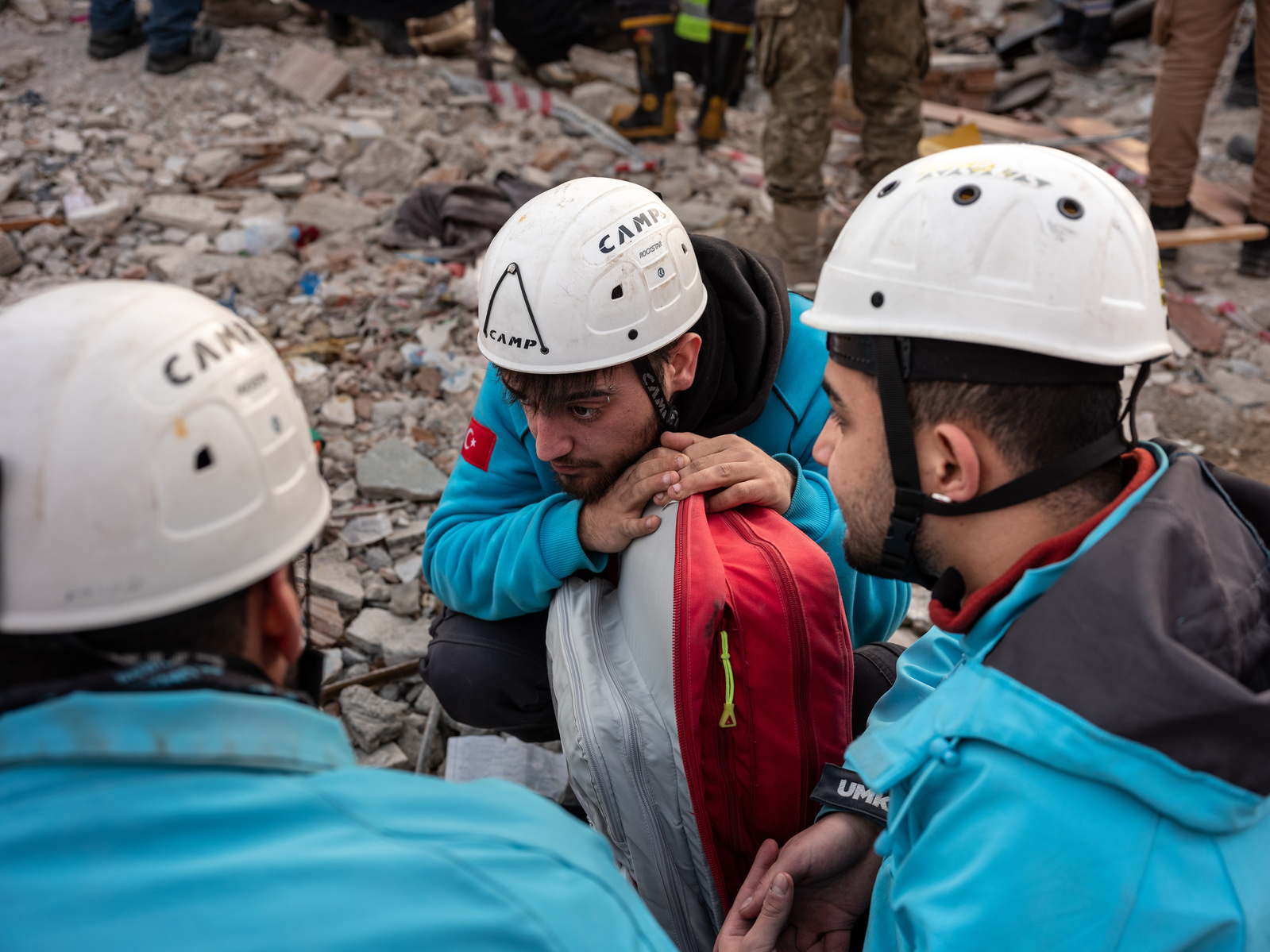 Volunteer rescuers take a minute of silence during the search to locate survivors buried under the rubble