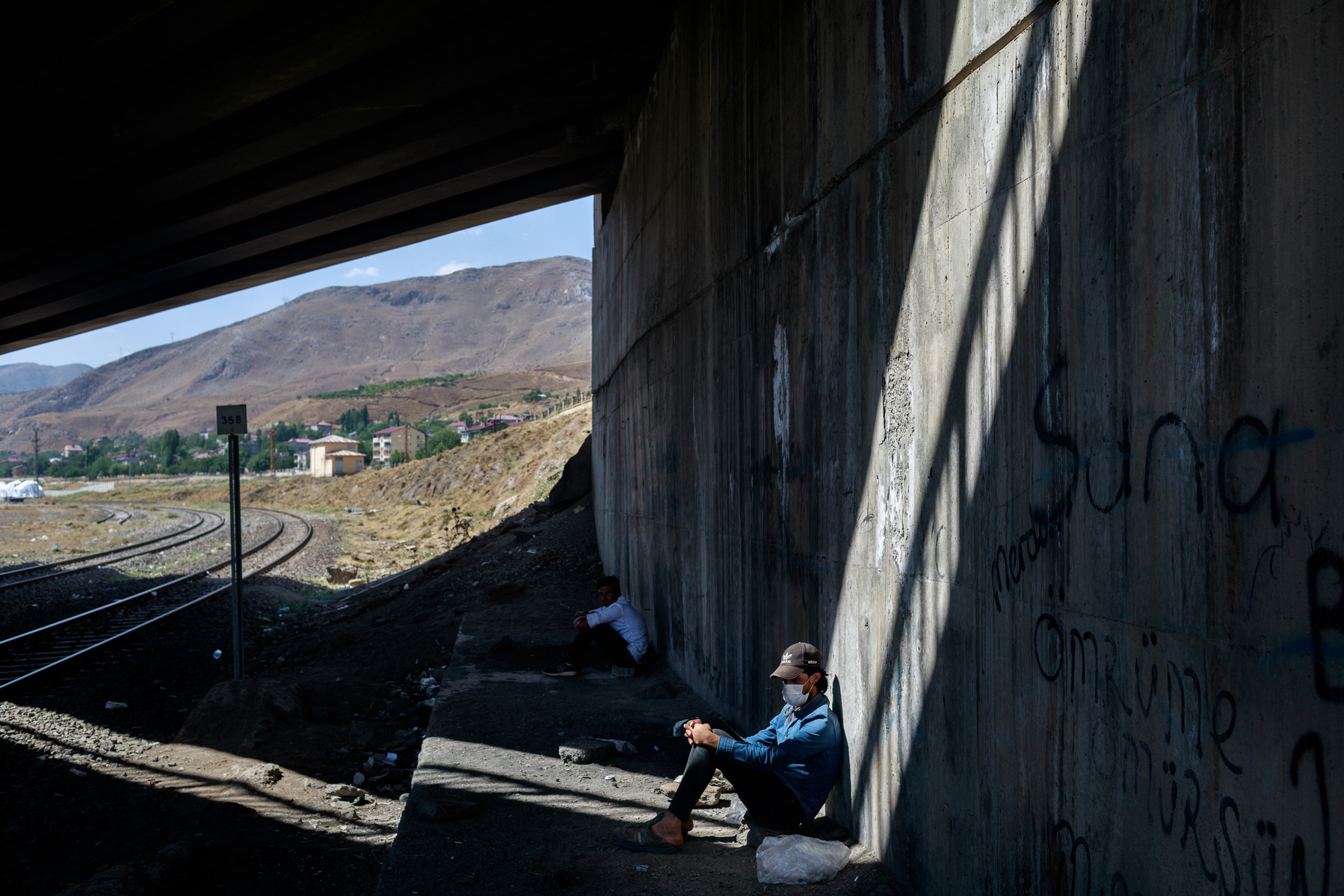 Young Afghans rest under a bridge, next to some railway lines on the outskirts of the eastern Turkish city of Tatvan. As Afghanistan comes under Taliban rule, tens of thousands have fled westward through Iran, and then Turkey, in search of safety, stabili