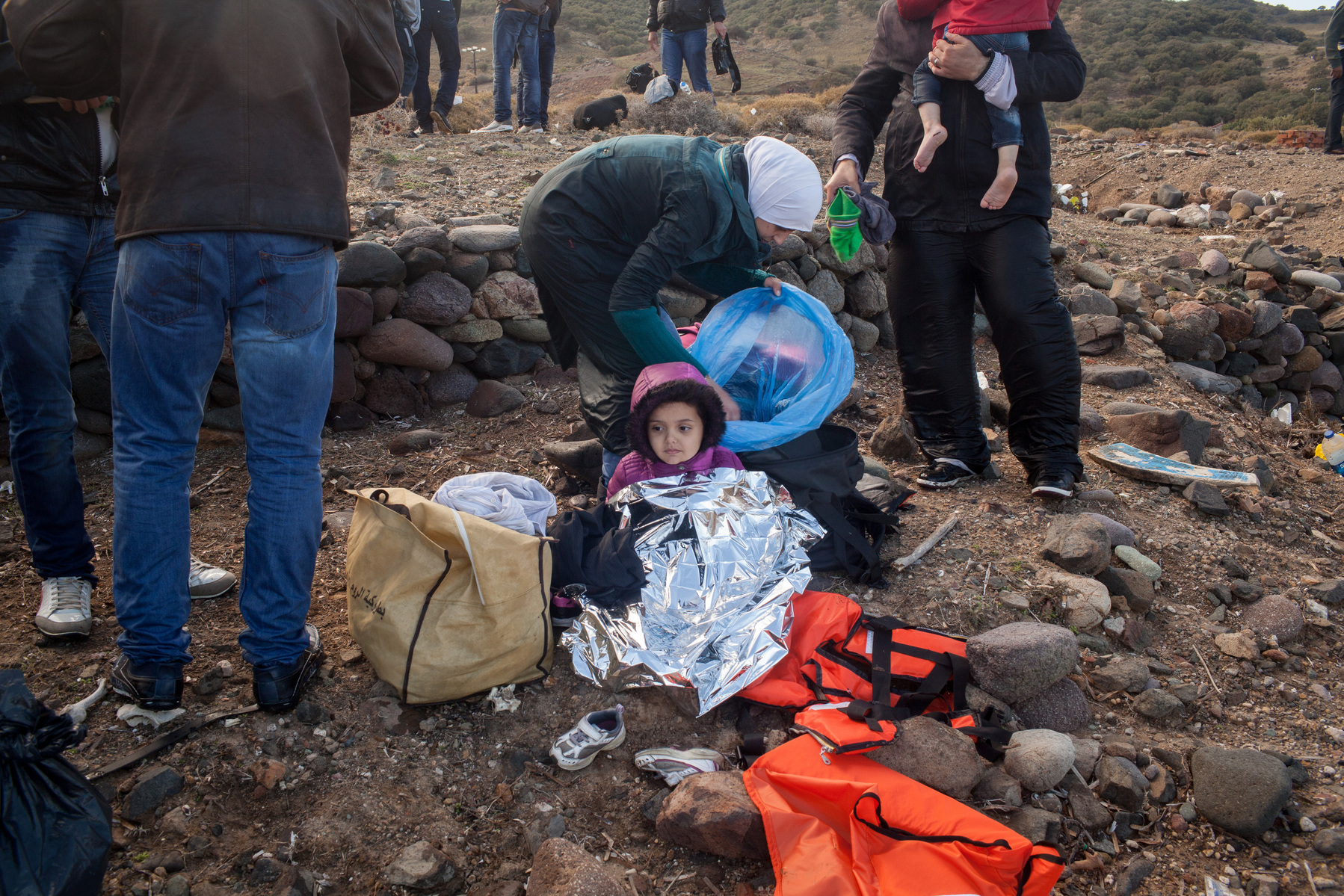 A young girl sits on a beach near Molyvos, Lesvos island in Greece, after just arriving in Europe by dinghy from Turkey.