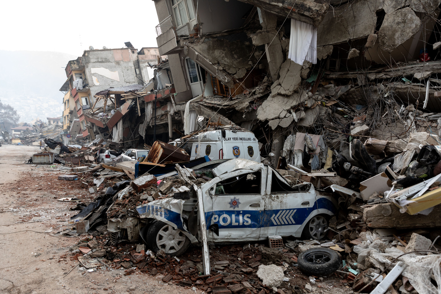 Police cars lay crushed under the rubble of buildings that collapsed as a result of the severe earthquakes which stuck in southern Turkey on the 6th of February 2023