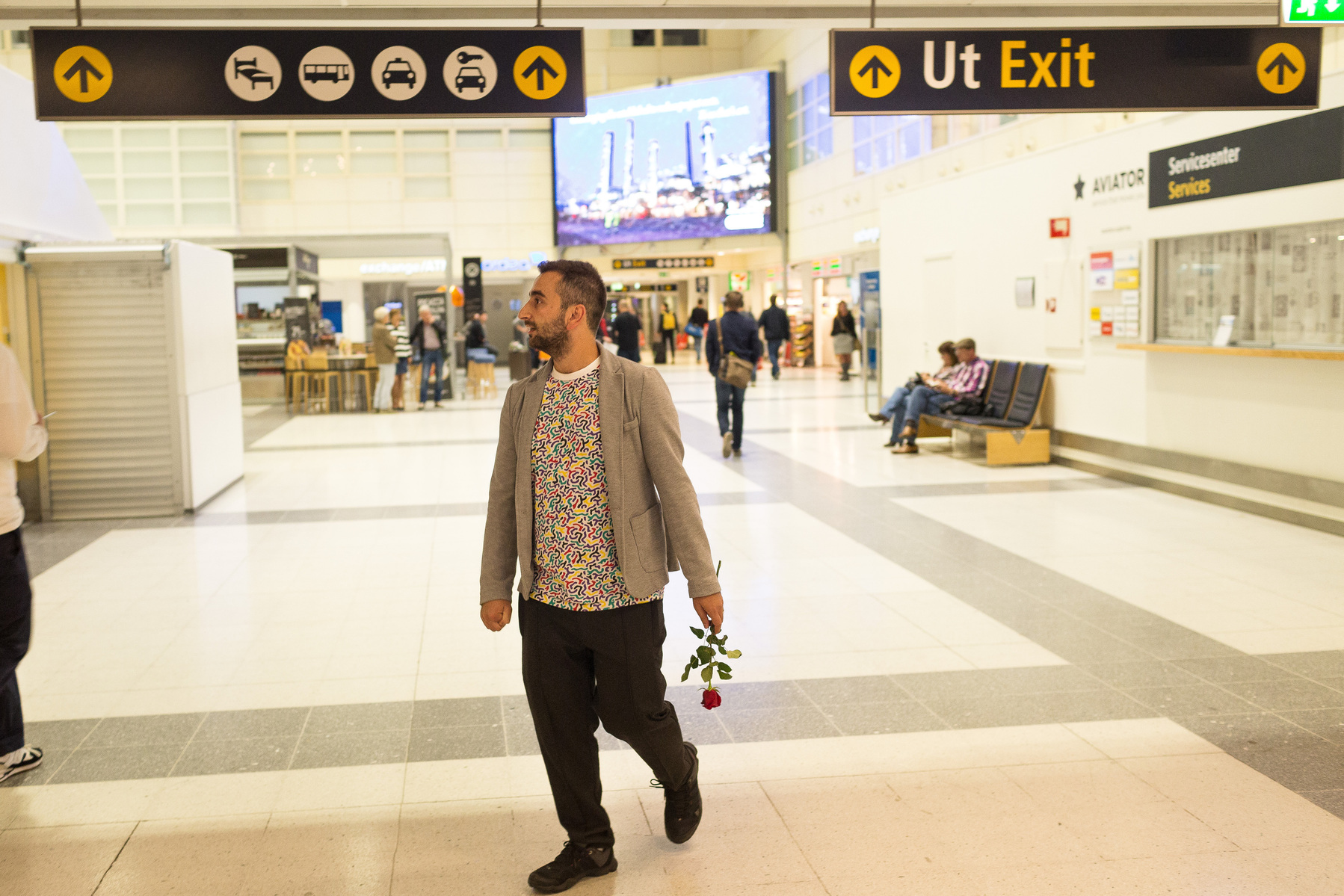 Nader checks the info screen and awaits Omar's arrival at Bergen airport just before middnight, after Omar spend more than 24 hours traveling from Istanbul due to a problem with his flight booking by the IOM.