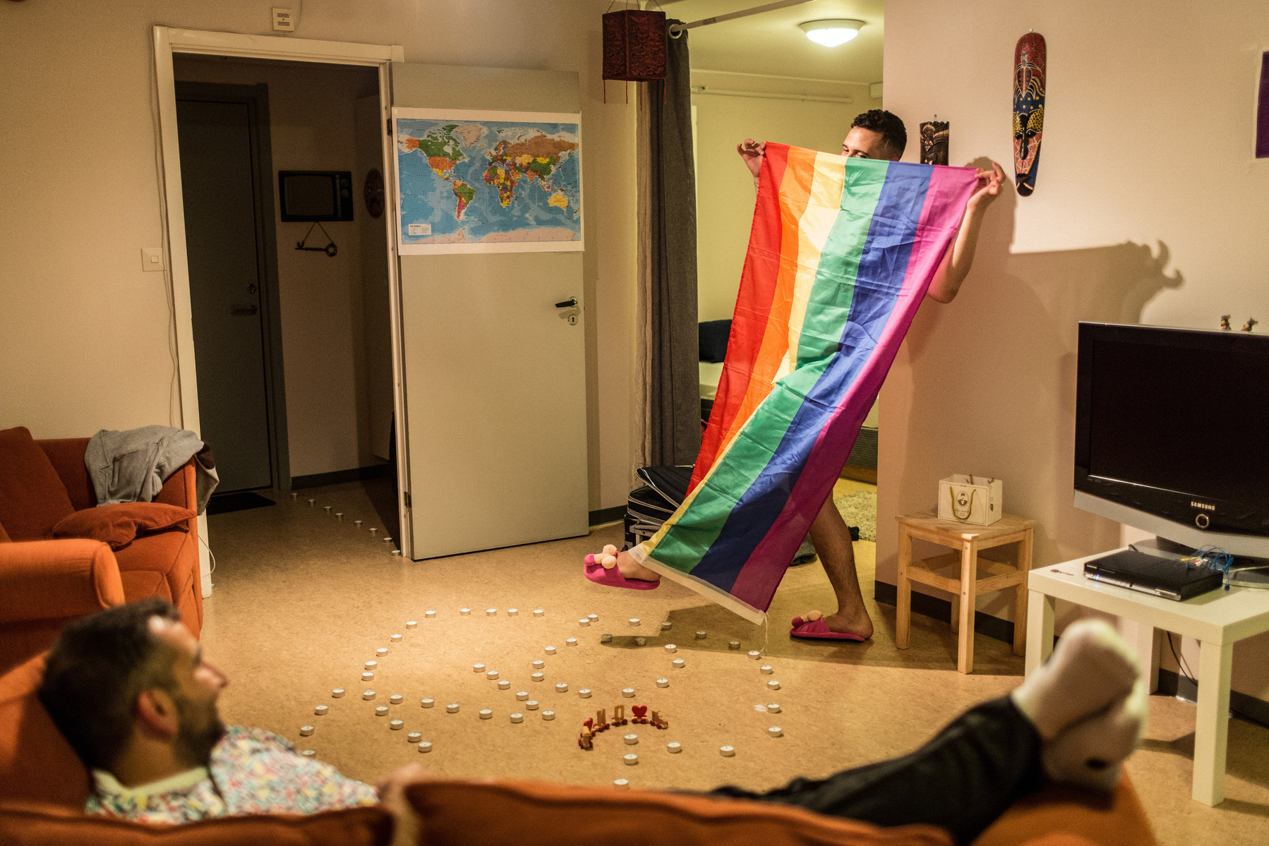 Omar unpacks his suitcases filled with trinkets from his previous home in Istanbul, Turkey, including his Pride flag, penis slippers, prayer rug, Quran, Turkish and Syrian sweets, and a dildo amongst his clothes.