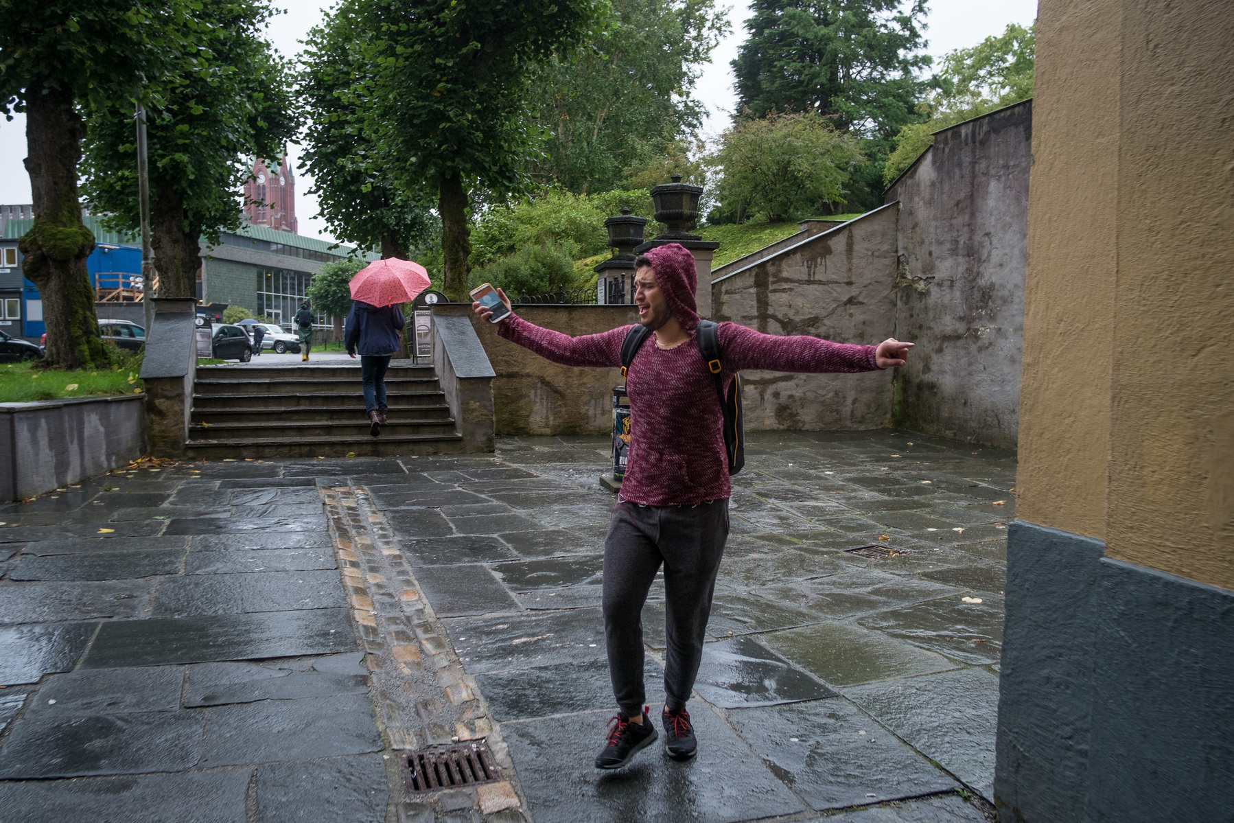 Omar dances in the rain whilst on the phone to a friend.