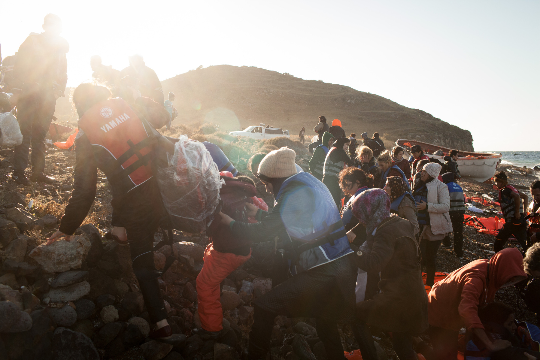 Migrants and refugees walk away from the dinghy they arrived on, after crossing from Turkey onto the Greek island of Lesvos.