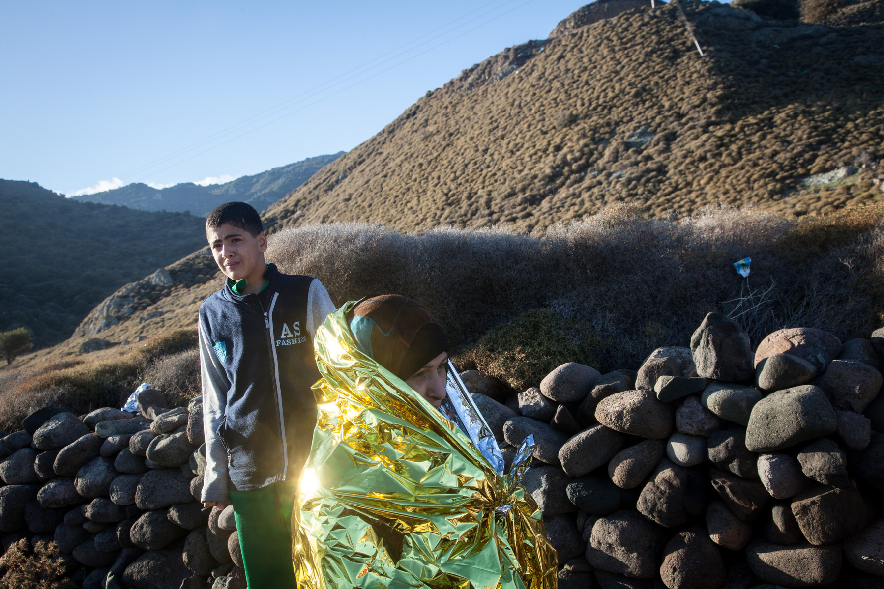 A mother and her son stand on the beach near Molyvos, Lesvos, Greece, after being smuggled on a boat from Turkey.