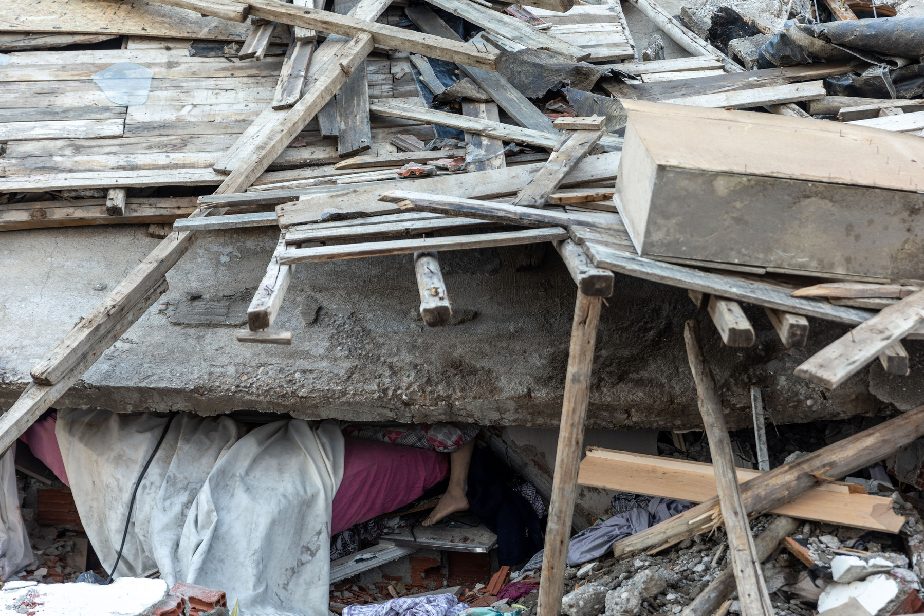 A deceased woman’s leg hangs from the ruins of her home, after she was crushed by the collapse of her building whilst sleeping in Kahramanmaras, southern Turkey, where a 7.9 earthquake struck in the early hours of Monday morning.
The destroyed southern