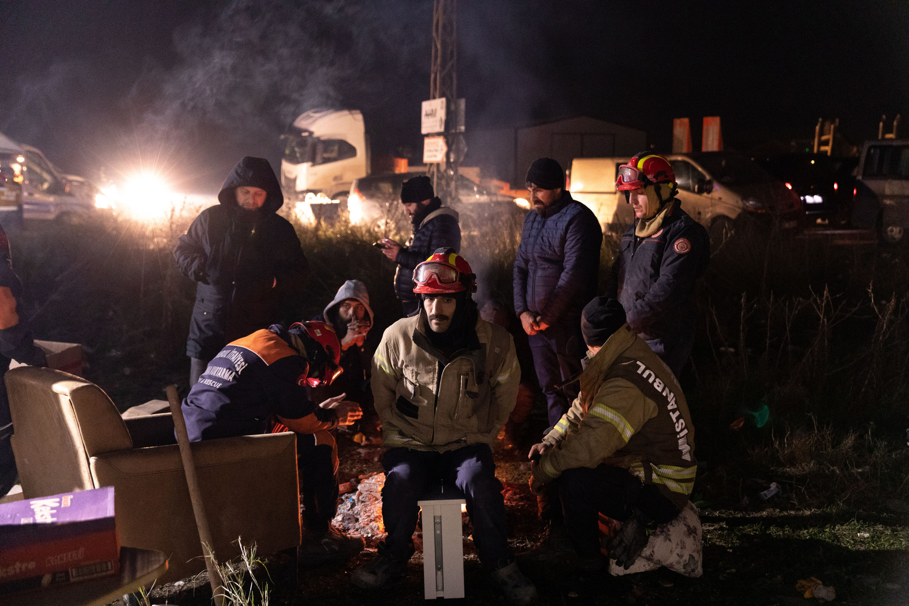 Firemen nd volunteer rescuers take a break between the rescue efforts to locate and retrieve survivors from the rubble of collapsed and damaged buildings in Antakya, Hatay, Turkey