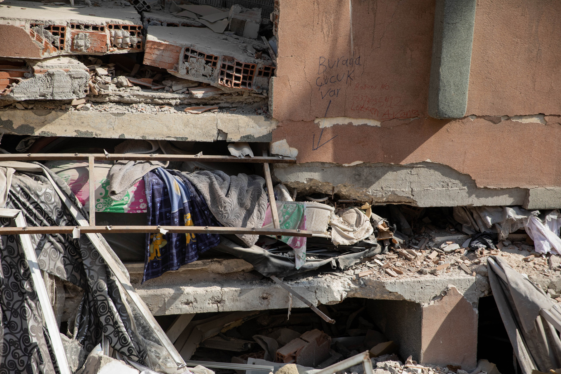 The body of 6 year old Syrian refugee Adem Ahdeb, lays inside his home, after the double earthquakes in southern Turkey last week caused the family home to collapse. The family wrote a sign on the wall saying "There's a child here" in Turkish, to ensure d