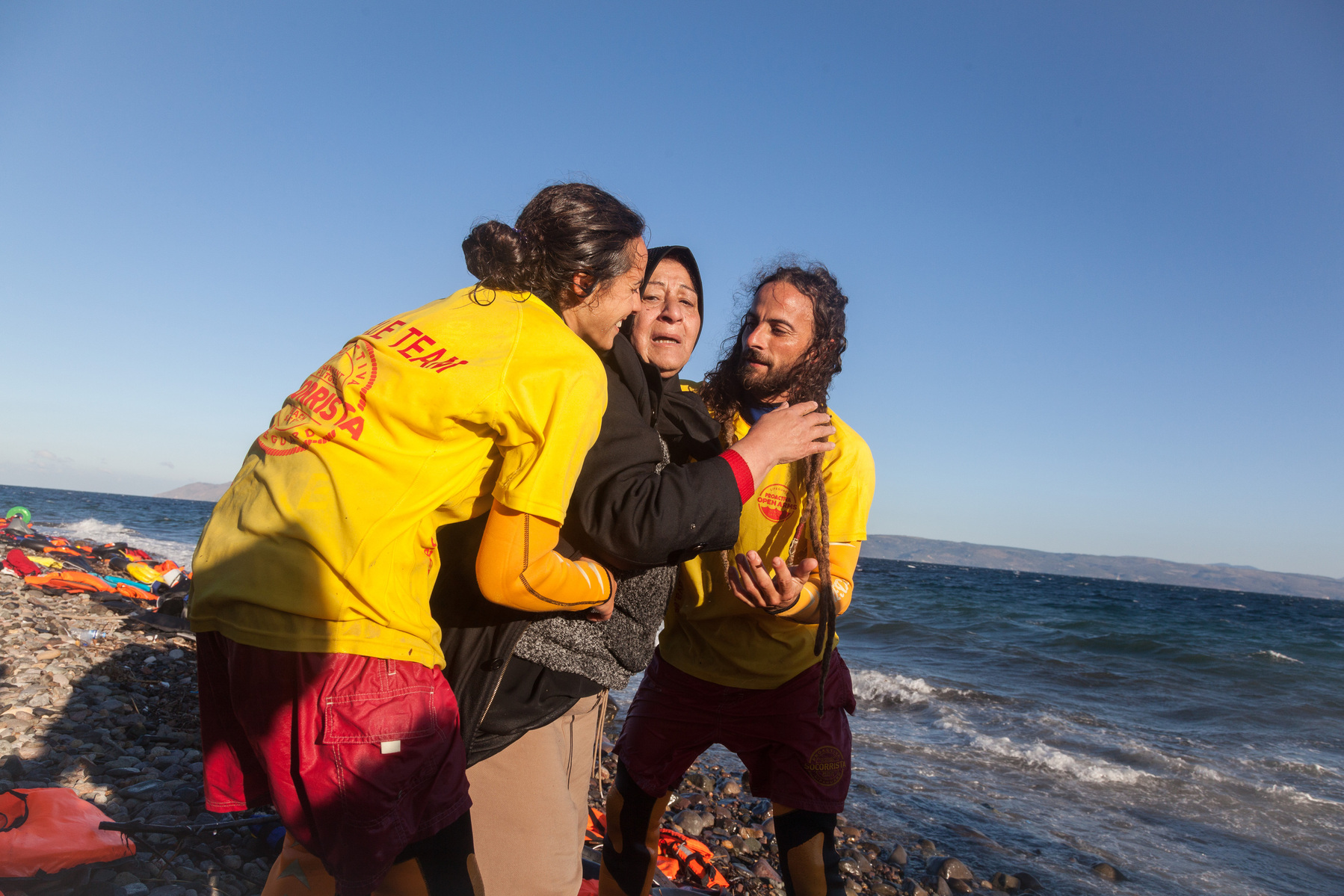 An Iraqi lady is helped to safety by Spanish volunteer lifeguards, after arriving on the Greek island of Lesvos.