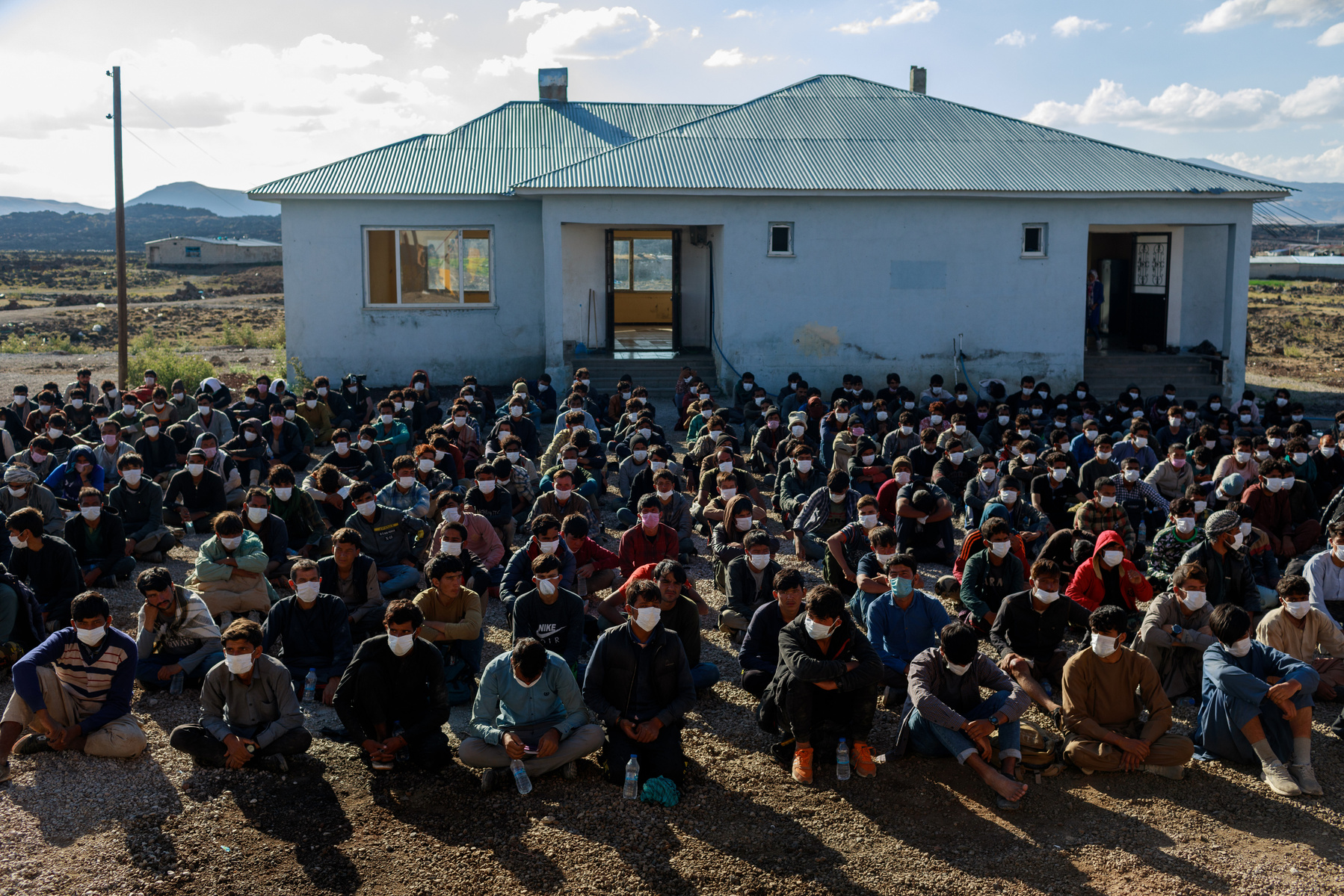 Approximately 400 migrants from Afghanistan, Pakistan, and Iran, who have been caught by the Turkish Jandarma and security services, await processing at a checkpoint near the town of Çaldiran, close to Turkey's border with Iran. Around 300 of these people