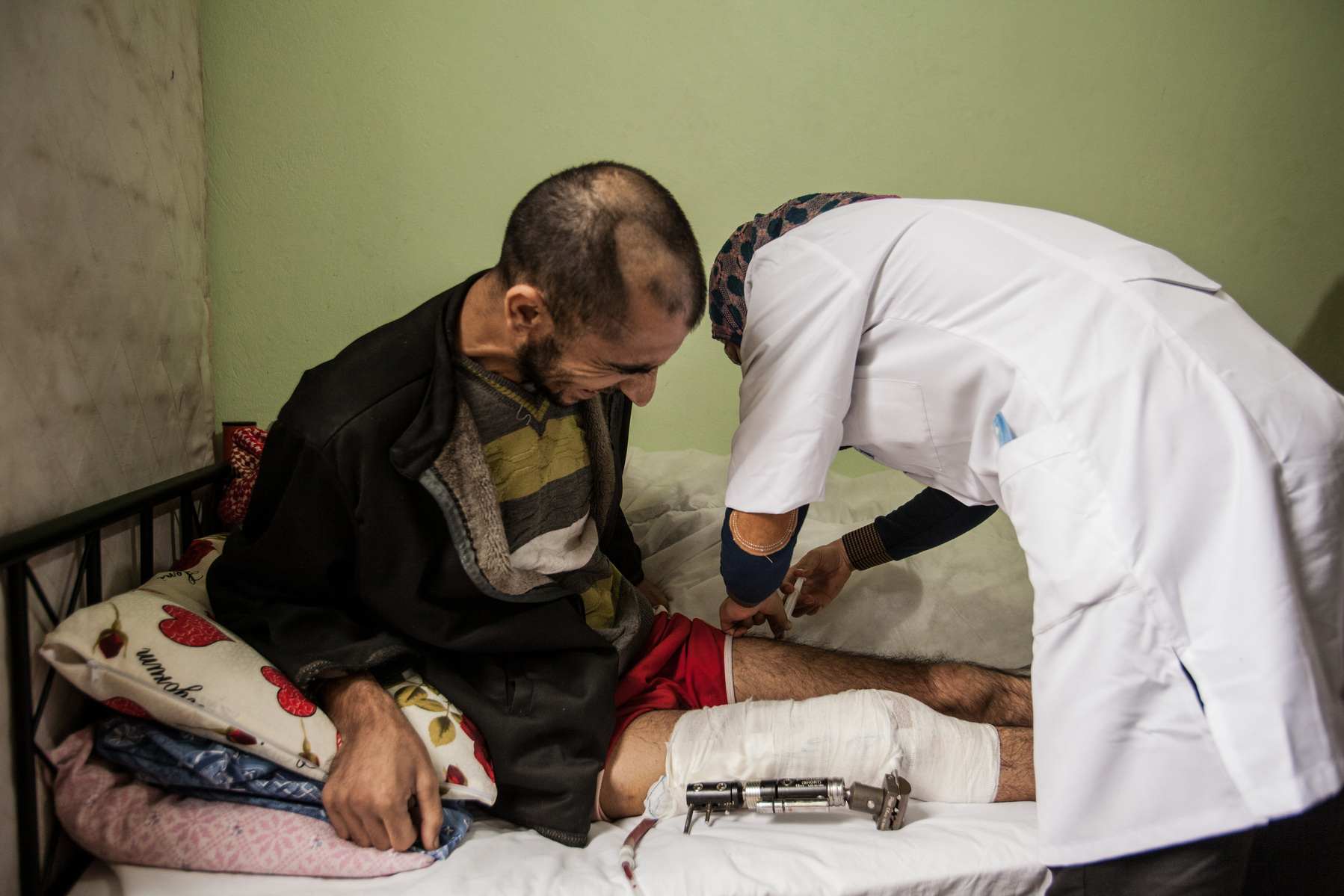 An injured Syrian patient received medical treament from a nurse, in a post-care centre for Syrians in the Turkish border town of Reyhanli. 04/01/2013