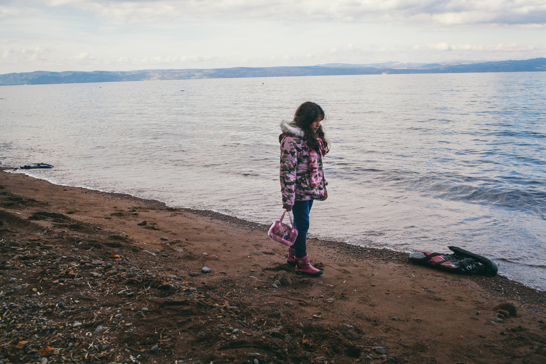 A Syrian girl on a beach near Molyvos, Lesvos island in Greece. She just arrived from Turkey on a rubber dinghy wearing her favourite clothes, all in matching pink.