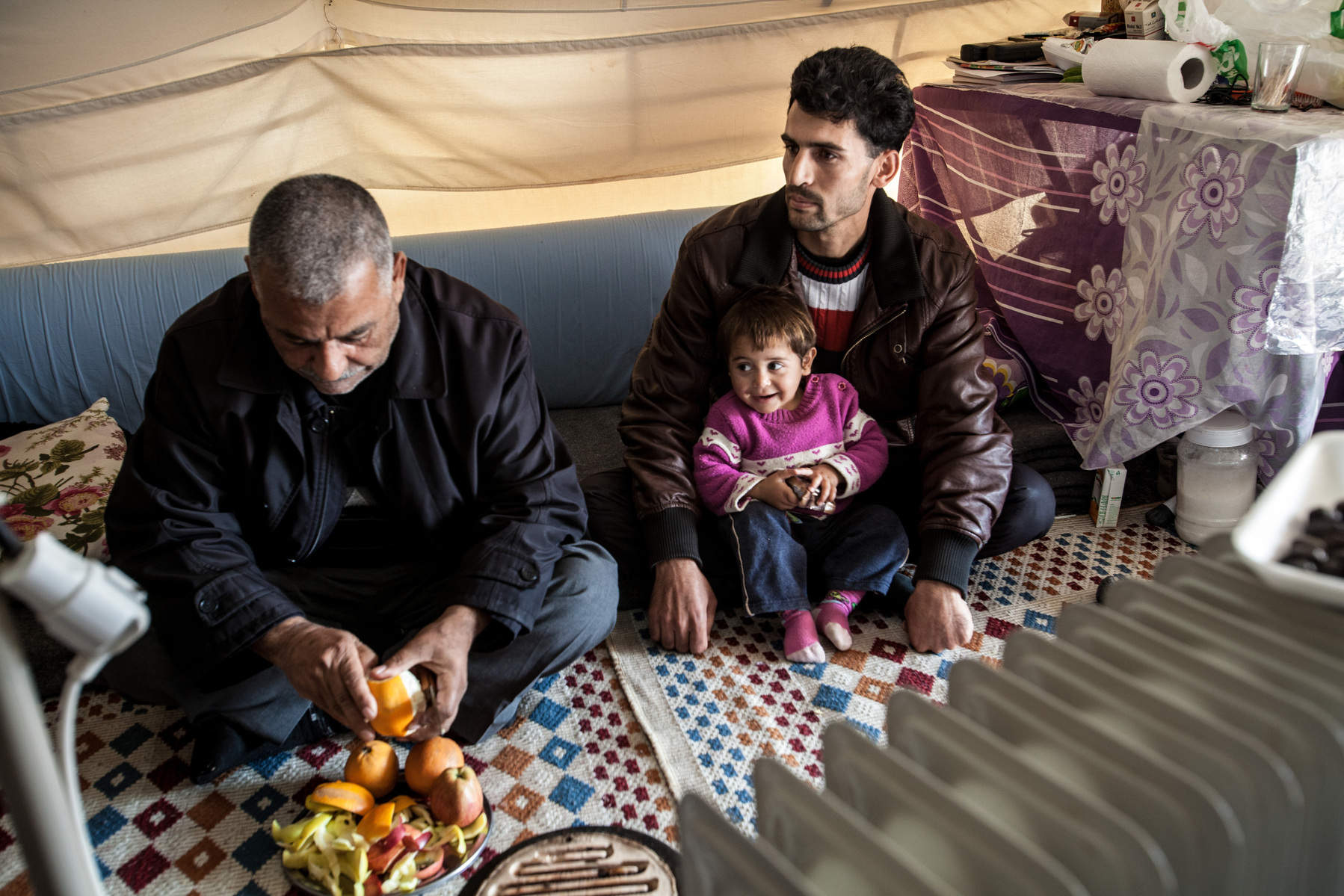 A Syrian family from Idlib province sit in their tent in Islahiye refugee camp, southern Turkey. 02/01/2013