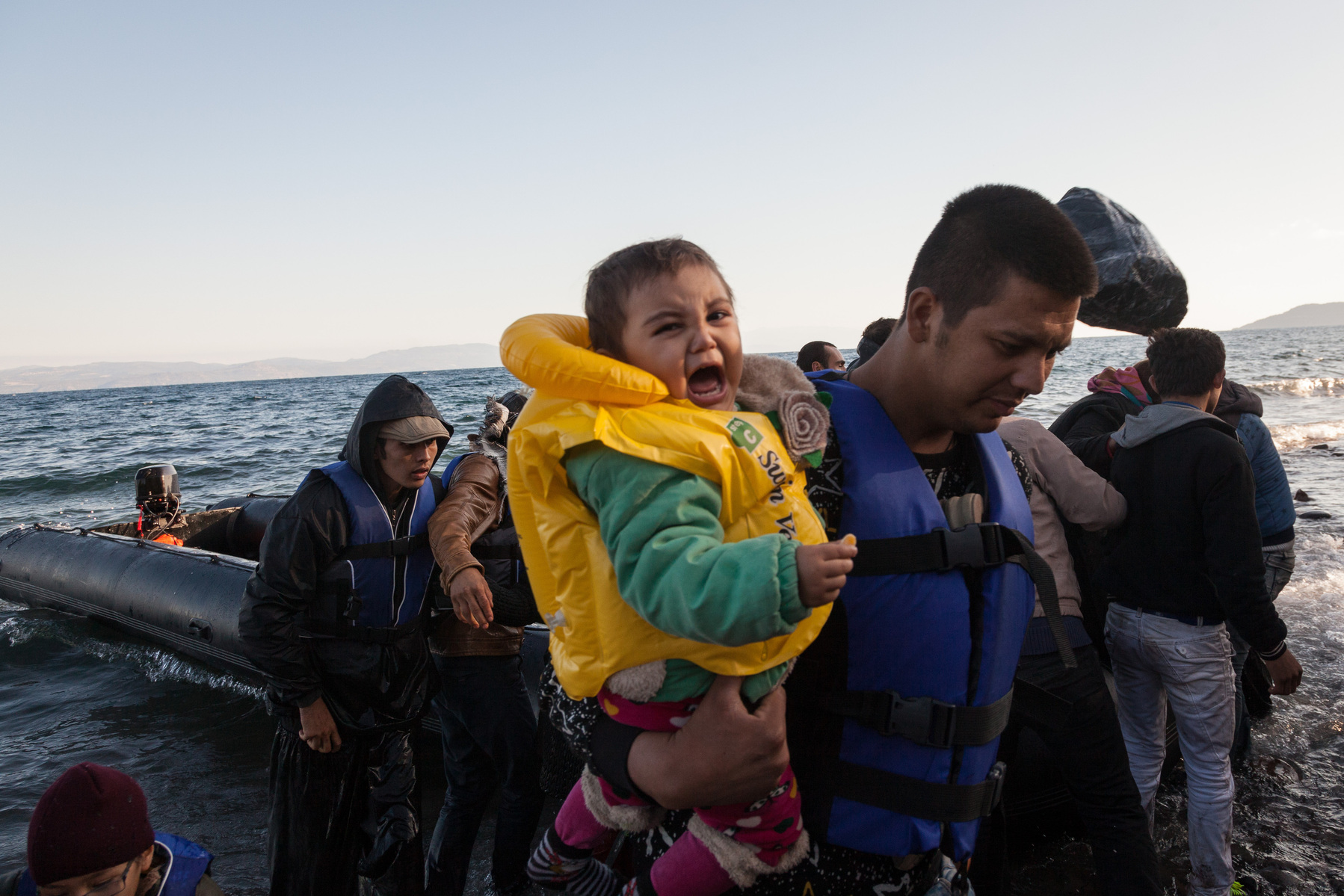 A father and holds his child as they arrive in Europe via a boat from Turkey. The number of refugees and migrants arriving to Europe in October 2015 was equal to the total arrivals of 2014 according to UNHCR figures.