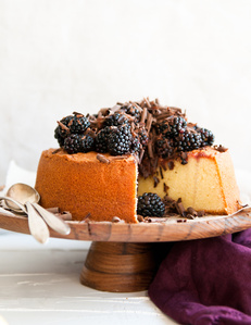 cake cut open with blackberries and chocolate dessert on stand