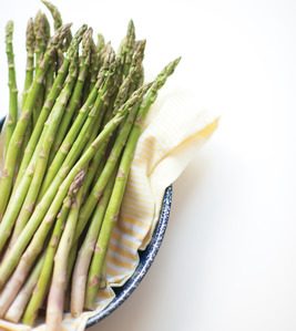 asparagus in a bowl with yellow dishcloth
