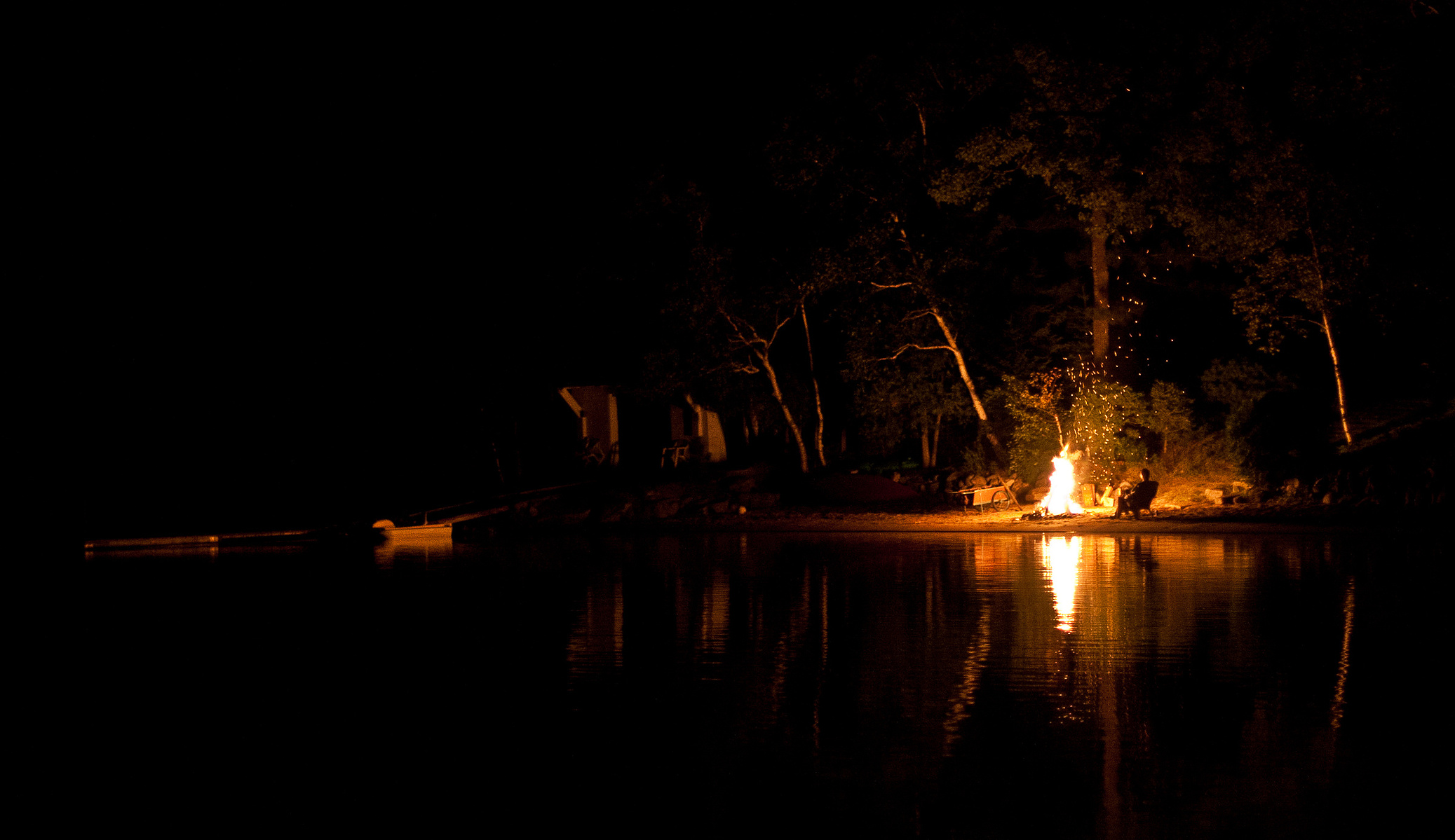 Campfire reflected in water of Lake St. Peter.