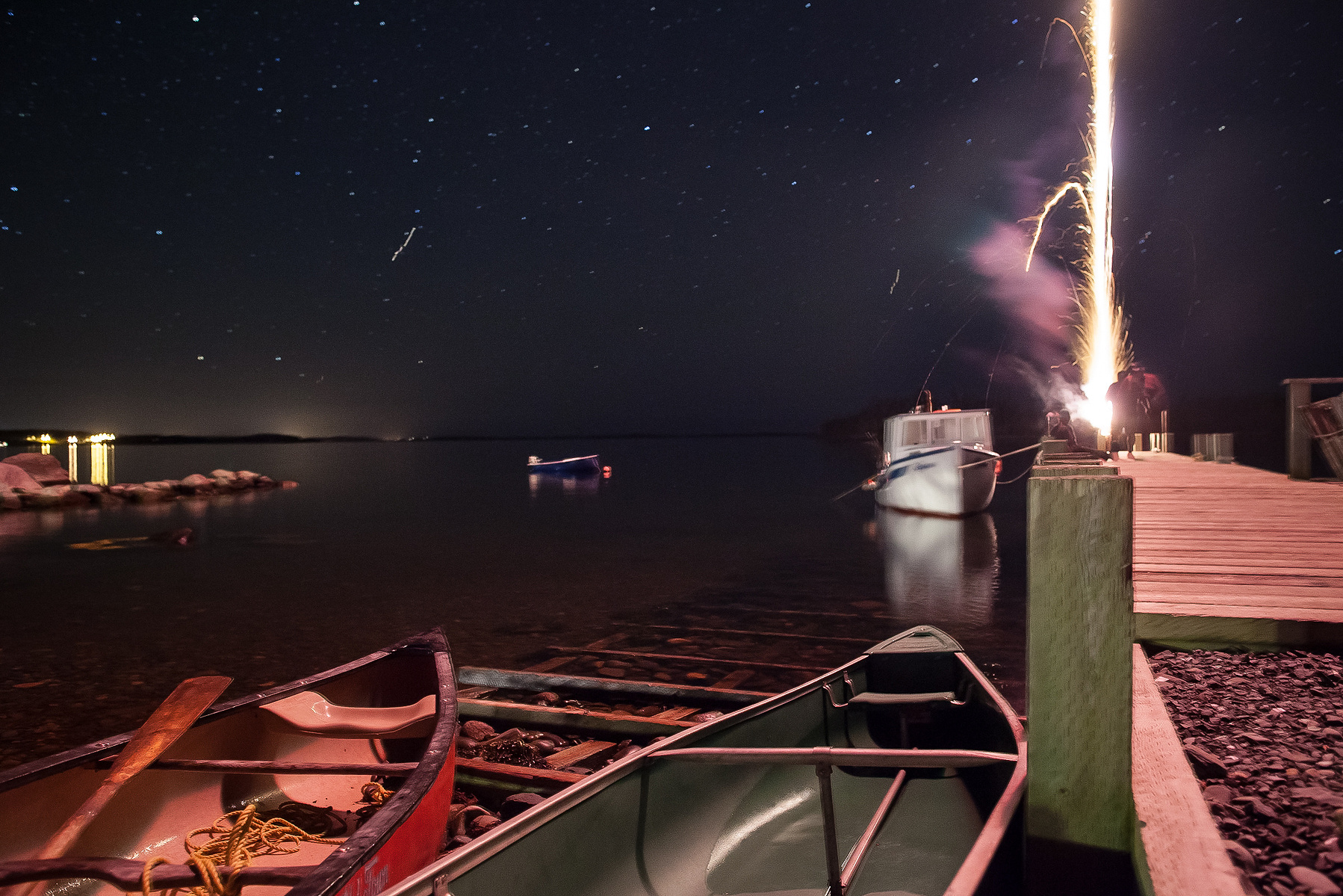 Firework trail over dock in Nova Scotia.