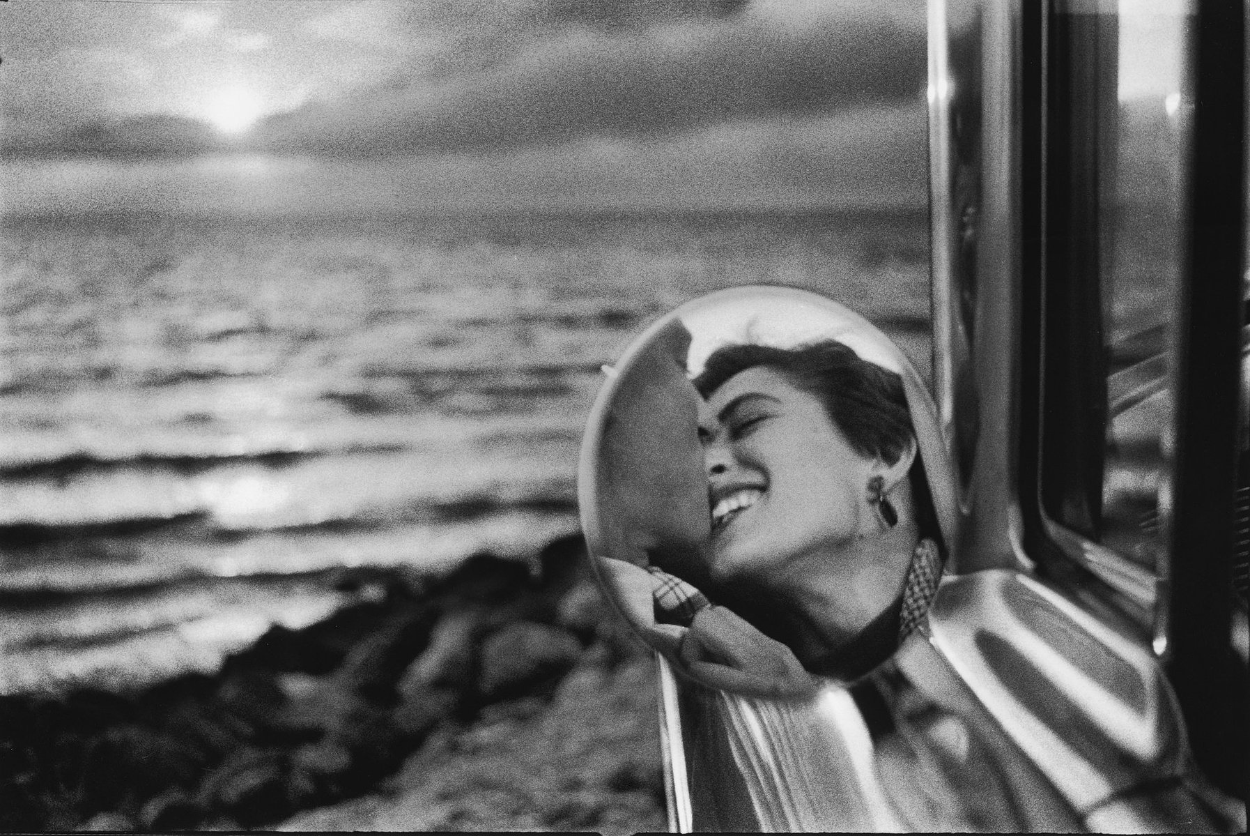 Découvrez une photographie iconique d’Elliott Erwitt capturant l’essence pure de l’amour. À travers un reflet délicat dans un rétroviseur, ce cliché en noir et blanc évoque la passion, la complicité, et la beauté intemporelle des émotions humaines. 