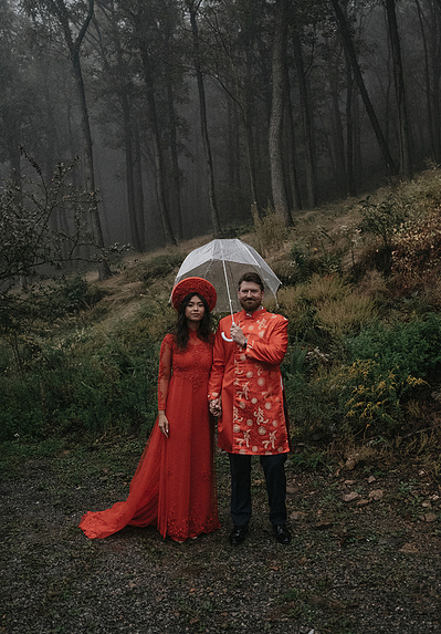 Bride and groom standing in the rain with mountains in the background, captured by a moody Connecticut wedding photographer.