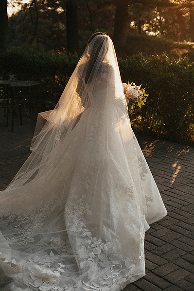 Bride walking down the aisle with sunlight glowing through her veil in the hills of Connecticut, captured by a dramatic CT wedding photographer.