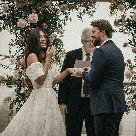 Bride and groom laughing during wedding ceremony with colorful mountain view, captured by a Connecticut wedding photographer.
