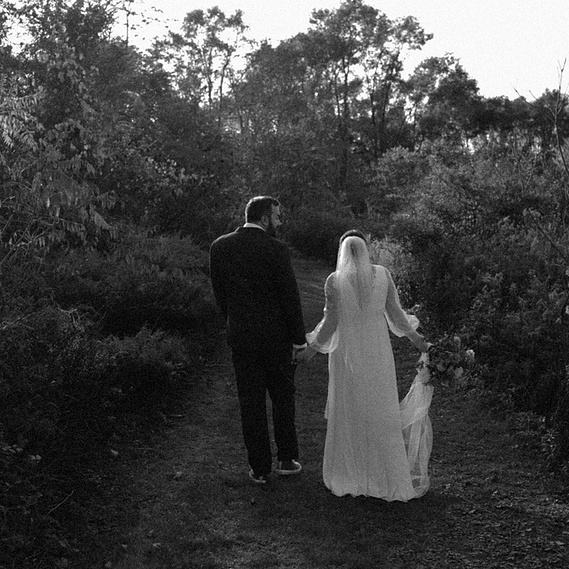 Bride and groom walking at Burkestone Estate in Hudson, New York with soft light on the bride’s dress — captured by a CT-based wedding photographer.”