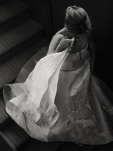 Bride walking down the stairs holding her dress — captured by a CT-based wedding photographer.