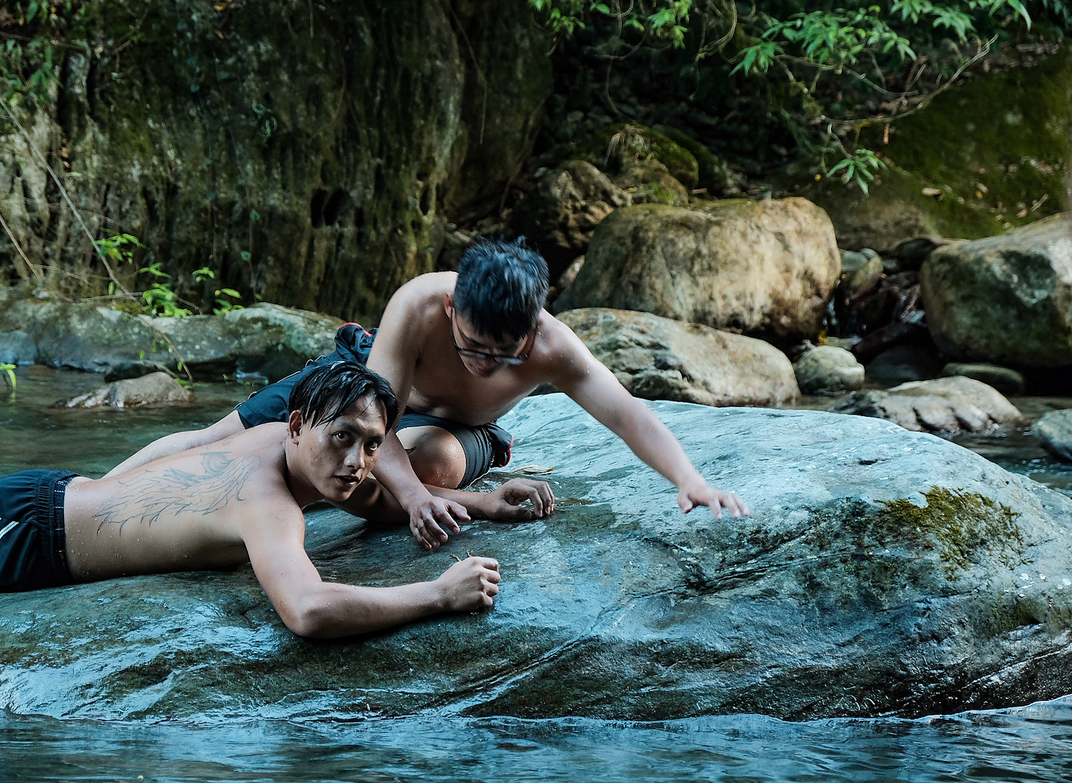 A couple of siblings that belong to the Atayal tribe lay on a rock while hunting for frogs