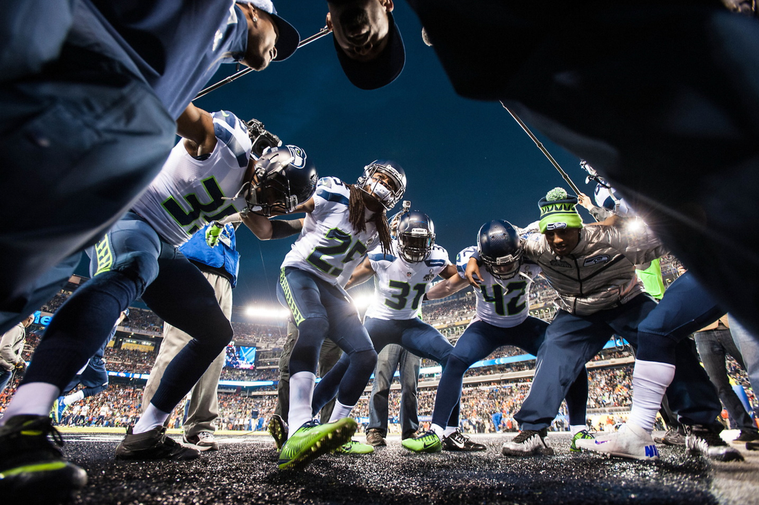 A wide angle pregame huddle image of Richard Sherman shot by Seattle Seahawks team photographer Rod Mar.