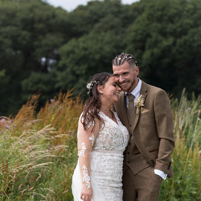 Bride and groom kissing in the meadow at Green Acres Rainford, St Helens, Merseyside