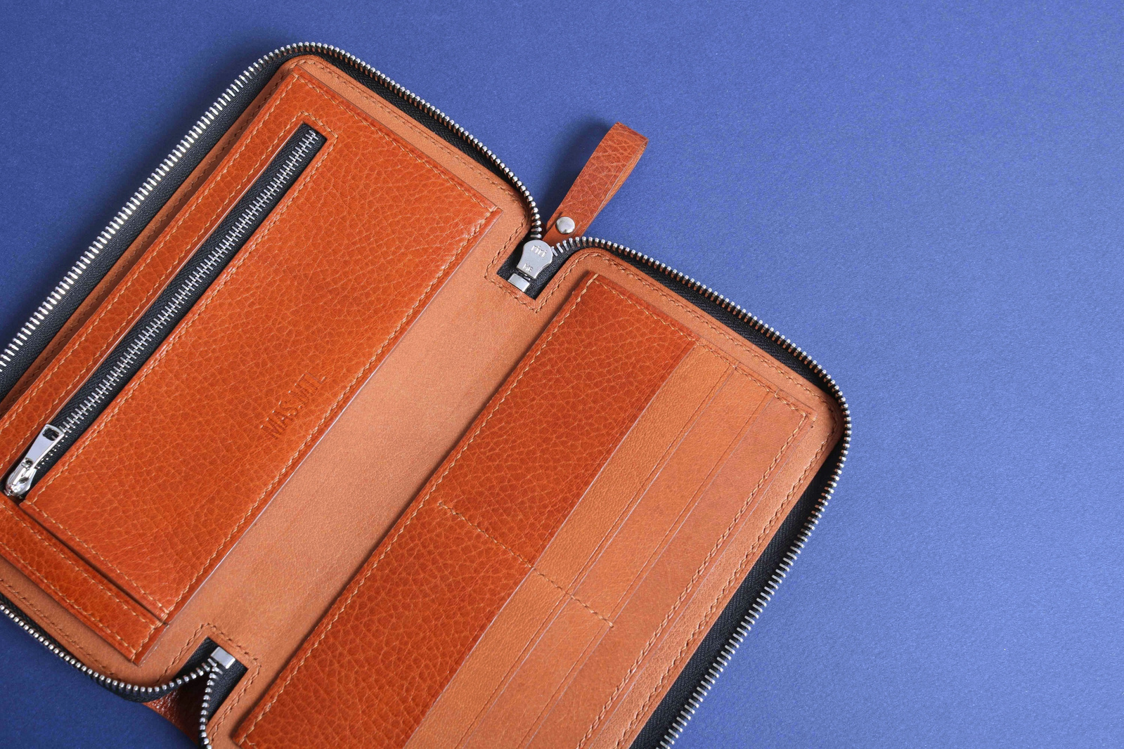 Le format compact de ce portefeuille n'enlève rien à la spaciosité de son organisation. Il compte deux grands compartiments pour les billets, six pochettes pour les cartes et une poche intérieure à fermeture à glissière pour la monnaie.